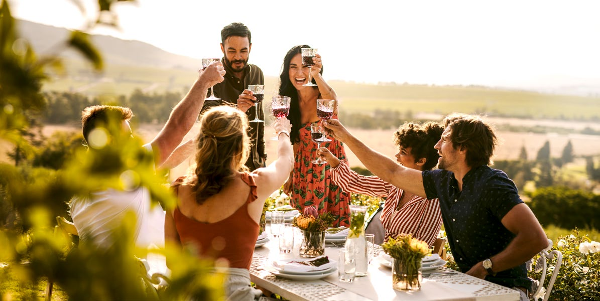 Freunde stoßen bei einem gemeinsamen Essen im Freien an